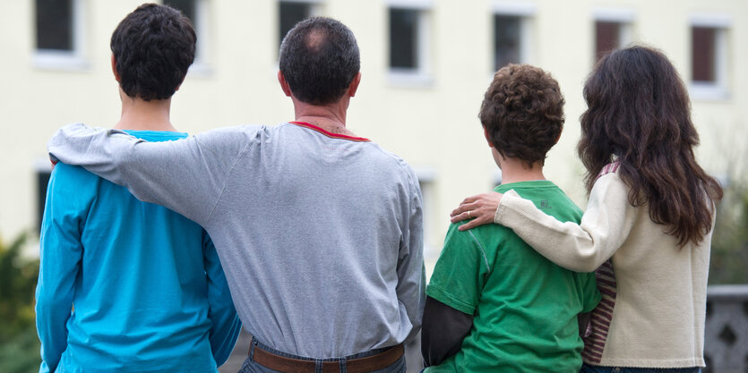 Zwei Erwachsene und zwei Kinder von hinten fotografiert