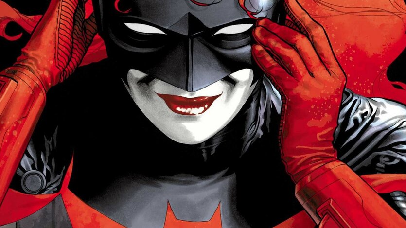 Auf dem Bild ist die Comicfigur Batwoman zu sehen. Sie hat feuerrote Haare und trägt eine Maske