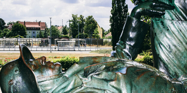 Blick auf den Bahnhof von Wurzen im Vordergrund ein liegender Soldat eines Kriegerdenkmals