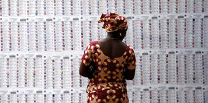 Eine Frau steht vor einem Wählerverzeichnis