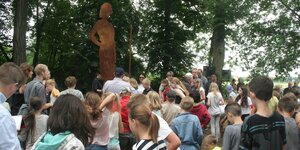 Viele Schulkinder stehen vor der Silhouette einer Frau – es ist ein Denkmal für Jutta Bamwoll, die im KZ ermodert wurde