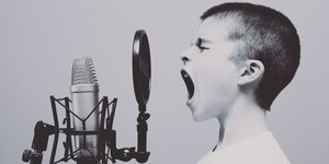 Ein Junge brüllt in ein Mikrofon