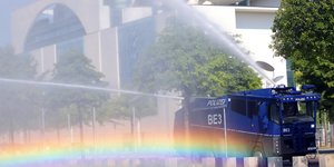 Ein Wasserwerfer der Polizei bewässert das Grün am Bundeskanzleramt in Berlin
