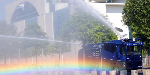 Ein Wasserwerfer der Polizei bewässert das Grün am Bundeskanzleramt in Berlin