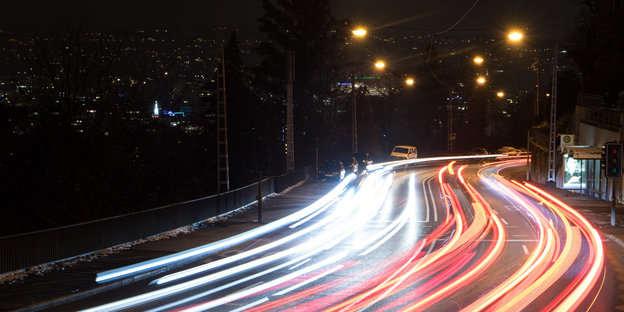 Scheinwerferlichter von Autos auf einer Straße bei Nacht