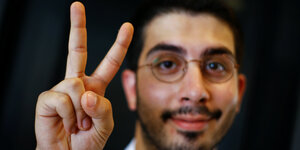 Ali Can hält die Hand zum Peace-Zeichen in die Kamera