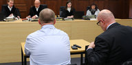Zeuge mit Anwalt sitzt vor Richtern