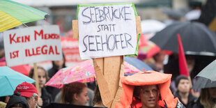 Demonstranten halten ein Schild mit der Aufschrift „Seebrücke statt Seehofer“ in die Höhe