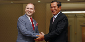 Kambodschas Premierminister Hun Sen gibt einem Wahlbeobachter der Parlamentswahl die Hand