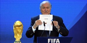 Joseph Blatter, damals FIFA Präsident, hält einen Zettel mit der Aufschrift «Katar» während der Bekanntgabe des Ausrichters der Fußball-WM 2022