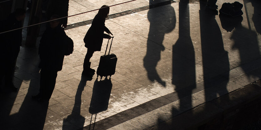 Silhouette einer Frau mit Rollkoffer