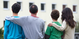 Syrische Familie sitzt vor einem Wohnheim