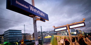 Ein Bahnhofsteig mit einem Schild auf dem "Düsseldorf Wehrhahn" steht