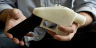 Eine Person hält eine Plastik-Pistole, die komplett im 3D-Drucker hergestellt wurde