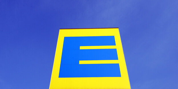Das blau-gelbe Edeka Logo vor blauem Himmel