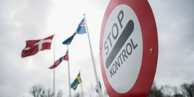 Ein rundes Schild mit rotem Rand. Darin die Worte Stop. Control. Im Hintergrund die schwedische Flagge