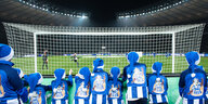 Kinde rin Hertha-Trikots stehen hinterm Tor im Olympiastadion