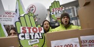 Protestaktion gegen CETA, Mehrere Menschen halten Plakate hoch