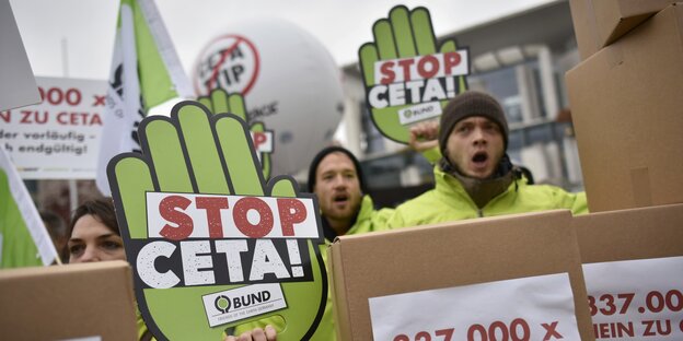 Protestaktion gegen CETA, Mehrere Menschen halten Plakate hoch