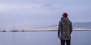 Aziz blickt am Hafen von Izmir auf das Meer hinaus