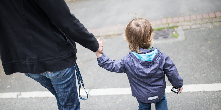 Eine Mutter hält ihren Sohn an der Hand