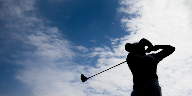 Golfspieler beim Schlag im Gegenlicht