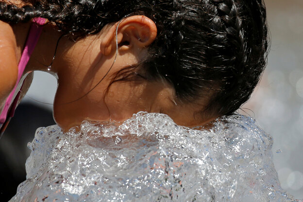 Mädchen mit geflochtenen Zöpfen hält Kopf ins Wasser