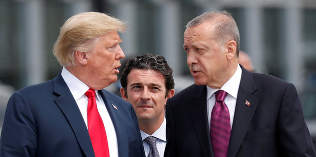 Trump und Erdoğan schauen sich an, ein weiterer beobachtet das von hinten
