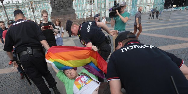 Polizisten tragen einen LGBT-Aktivisten weg