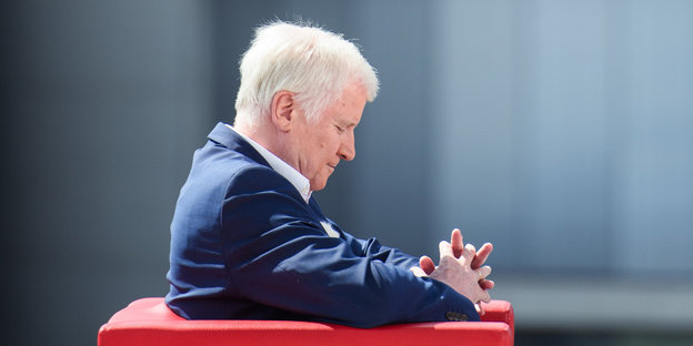 Innenminister Horst Seehofer sitzt auf einem roten Sofa