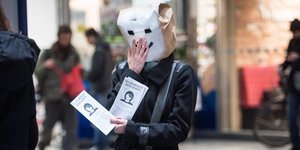 Eine Demonstrantin mit einer Tüte über dem Kopf.
