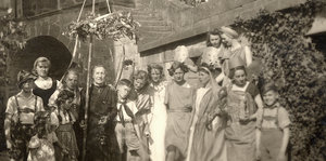 eine alte Schwarz-Weiß-Aufnahme: eine Gruppe von Menschen, teilweise in antiken Kostümen