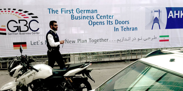 Ein Mann geht in Teheran an einem Plakat vorbei
