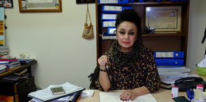 eine Frau sitzt hinter einem Schreibtisch