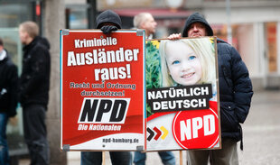 Zwei NDP-Anhänger halten NPD-Wahlkampfplakate.