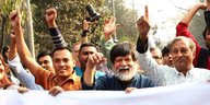 Shahidul Alam und andere Männer heben ihre Fäuste