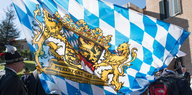 ene Bayern-Fahne und Menschen in Tracht
