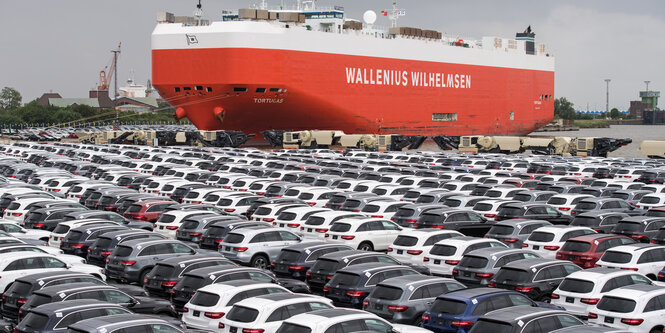 Neuwagen von Mercedes-Benz auf einem Parkplatz, dahinter Schiff