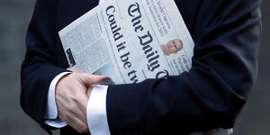 Ein Mann hält den "Daily Telegraph"