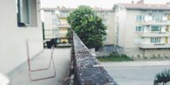 Die vermoderte Brüstung eines Balkons in einem tristen Wohnviertel