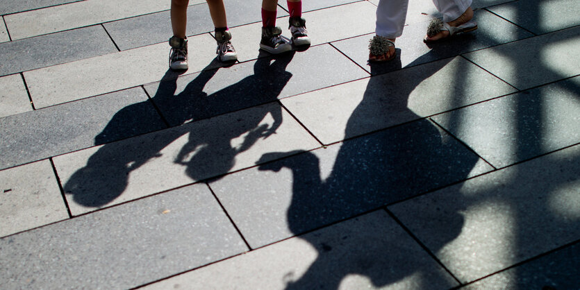 Zwei Kinder werfen in der Sonne einen Schatten