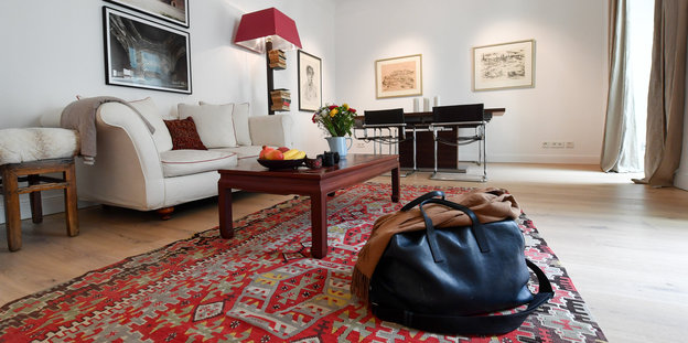 Wohnzimmer mit Reisetasche auf einem Teppich