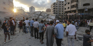 Palästinenser stehen in den Trümmern eines zerstörten Gebäudes