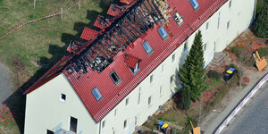 Ein großes Wohnhaus von oben mit ausgebrannten Dachstuhl
