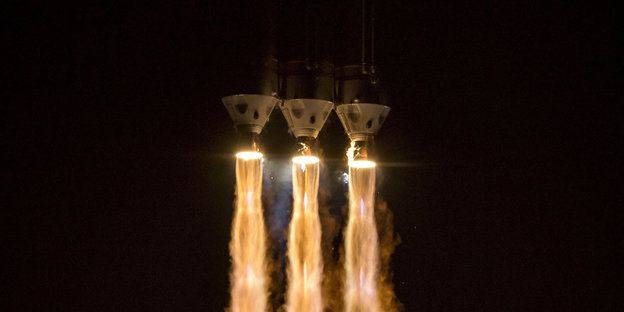 Drei Raketen starten vor einem Nachthimmel