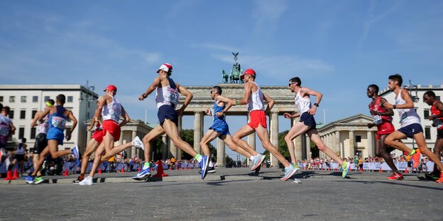 Viele Männer laufen vor dem Brandenburger Tor in Berlin