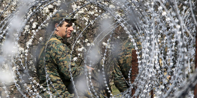 Soldat hinter Stacheldraht