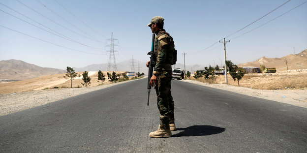 Ein afghanischer Soldat überwacht einen Checkpoint an der Straße
