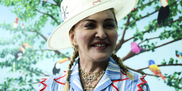US-Sängerin Madonna trägt einen Hut vor einer Leinwand mit einem Baum- und Vogelmotiv