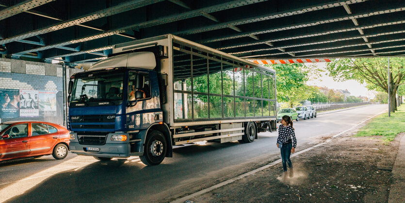 Der umgebaute LKW der Theater-Performance und sein Guide stehen unter einer Brücke.